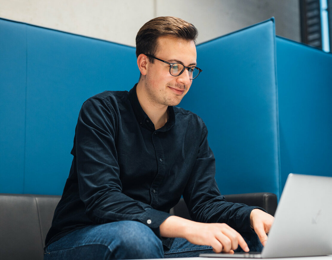 Student am Laptop in Sitzecke