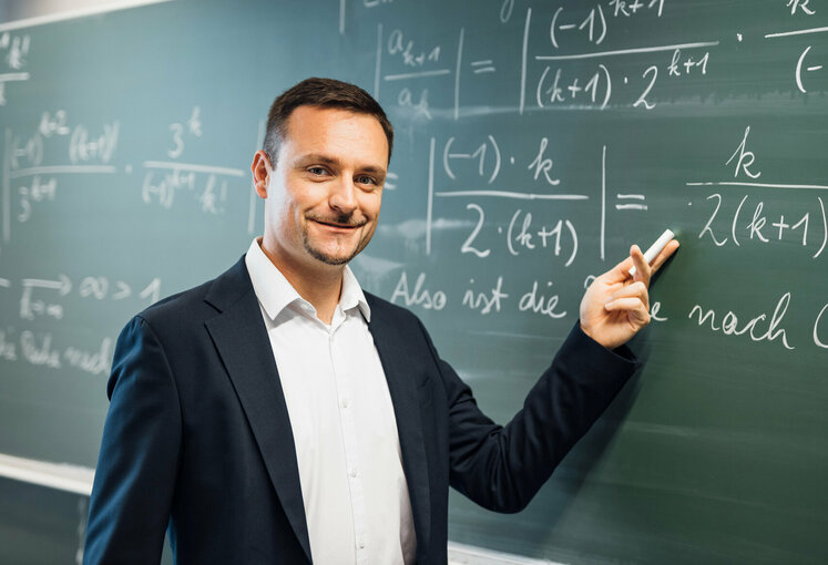 Professor zeigt an Tafel den Aufschrieb